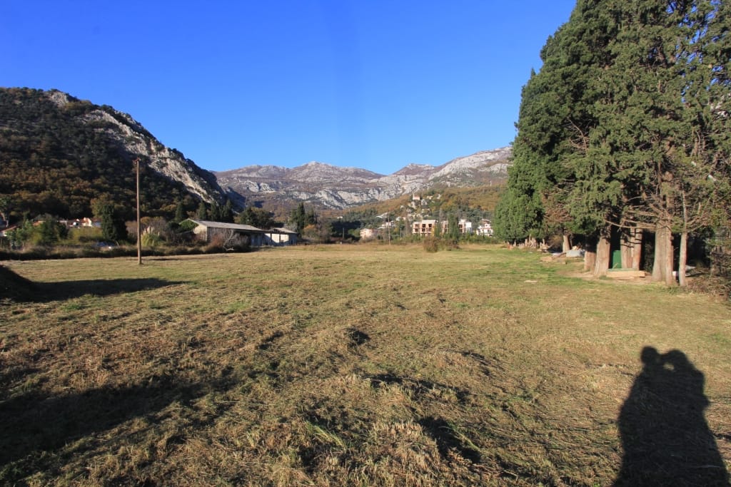 Building plot in Buljarica, Montenegro: flat terrain with mountain views and a cypress alley.