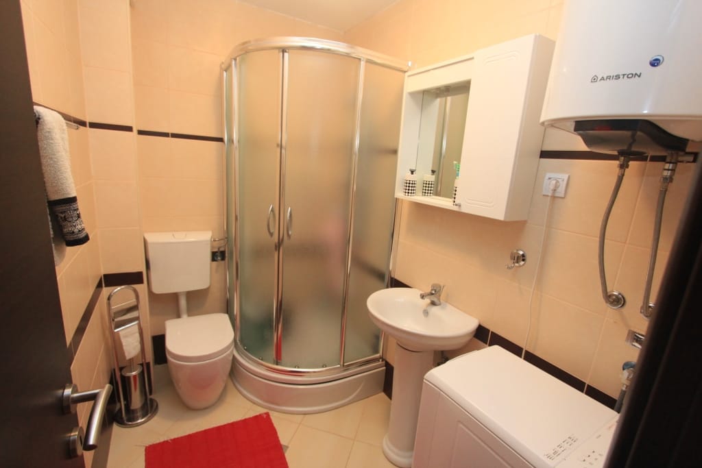 Bathroom in an apartment in Rafailovici, Montenegro: shower cabin, sink, toilet, and Ariston water heater.