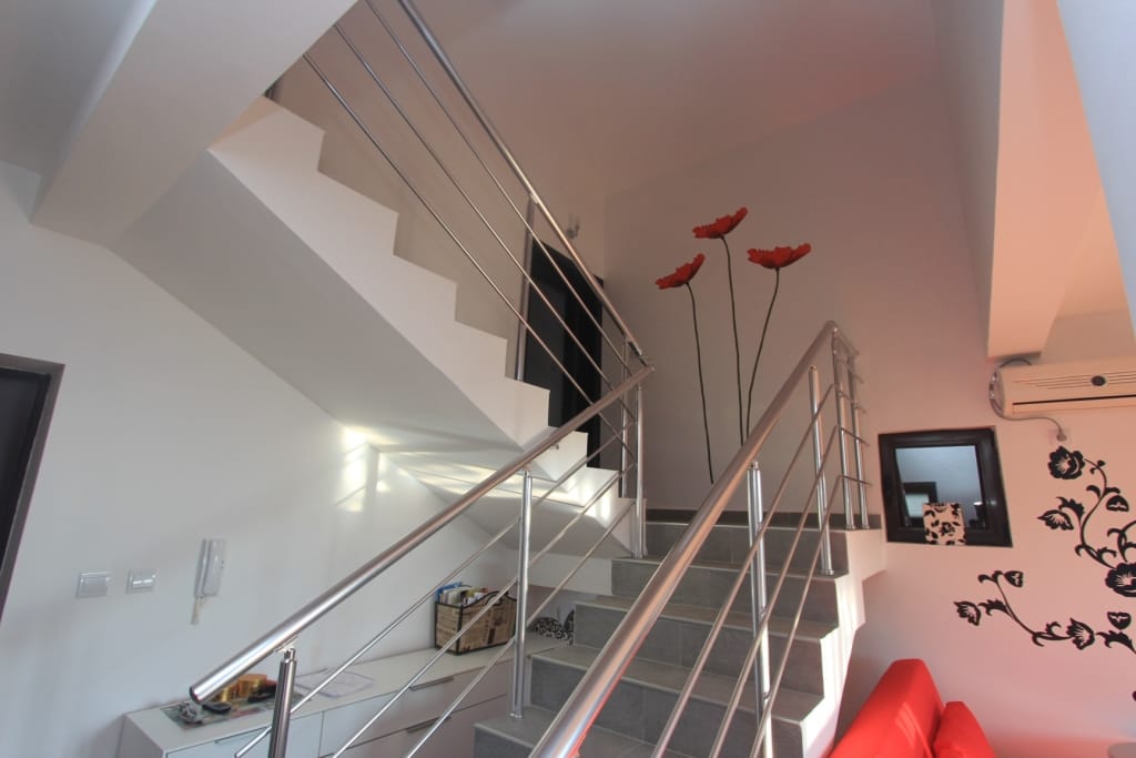 Modern staircase with metal railings in an apartment interior in Rafailovici, Montenegro.