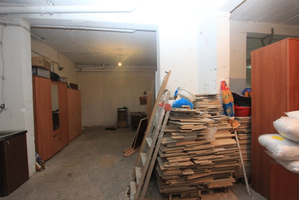 Technical storage room in Rafailovici, Montenegro: concrete walls, wooden cabinets, and construction materials.
