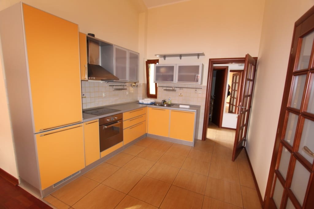 Modern kitchen with orange cabinet fronts and built-in appliances in a mini-hotel, Igalo, Montenegro.