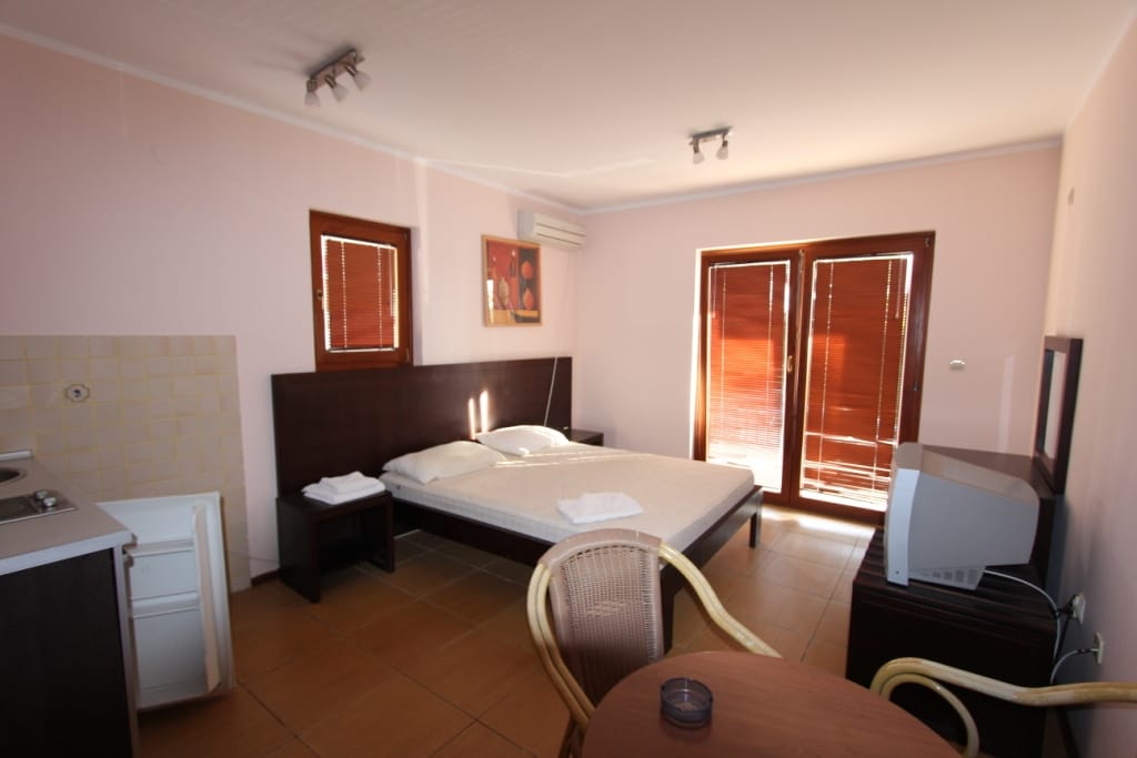 Bedroom with a double bed, kitchenette, and access to the terrace in a mini-hotel, Igalo, Montenegro.