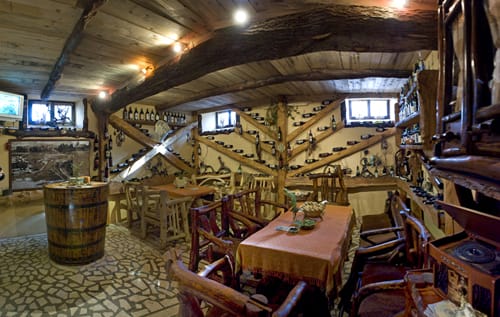 Wine cellar of a restaurant in Virpazar, Montenegro: natural wood interior, wine shelves, and log furniture.