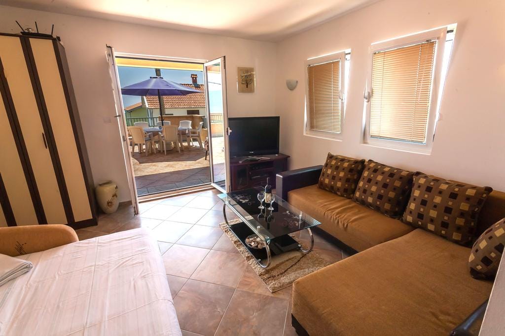 Living room with a soft sofa and access to the terrace in a house, Krimovica, Montenegro. Bright interior with furniture.