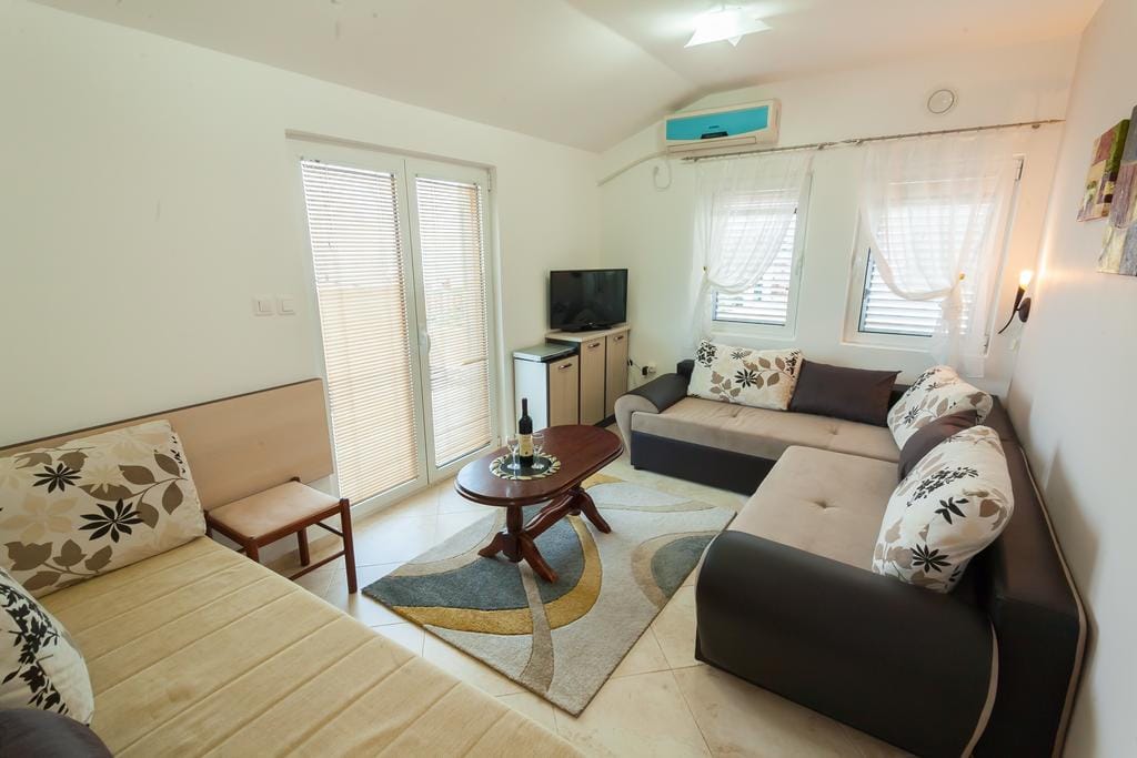 Cozy living room with a sofa set and TV in a house for sale, Krimovica, Montenegro: bright interior, tiled floor.