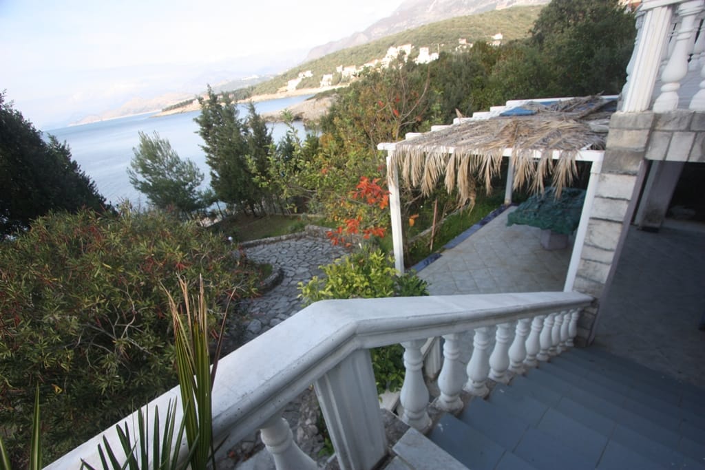 View from the terrace of a house in Utjeha, Montenegro: stone staircase, gazebo with canopy, and panoramic sea and mountain views.