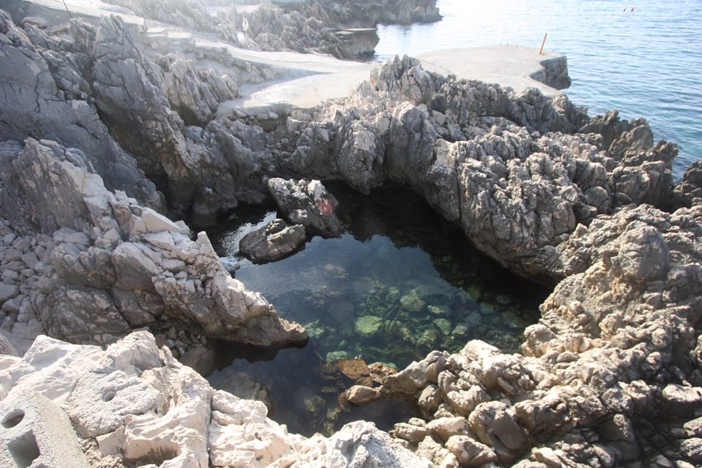 Natural rock pool by the sea near the house in Uteha, Montenegro, with clear water and a rocky shore.