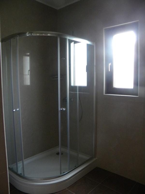 Modern bathroom with a shower cabin in a villa, Herceg Novi, Montenegro: stylish finishes and a window.