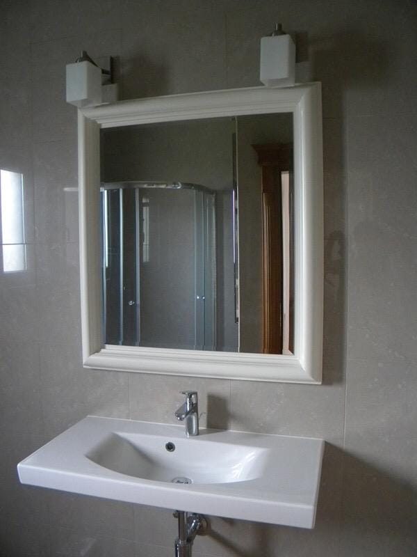 Modern bathroom in a villa, Herceg Novi, Montenegro: white sink, framed mirror, and shower cabin.