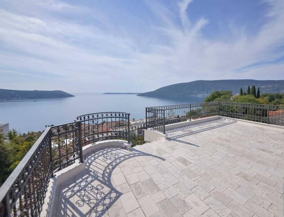 Spacious terrace with wrought-iron railing and panoramic views of the sea and mountains, villa in Herceg Novi, Montenegro.