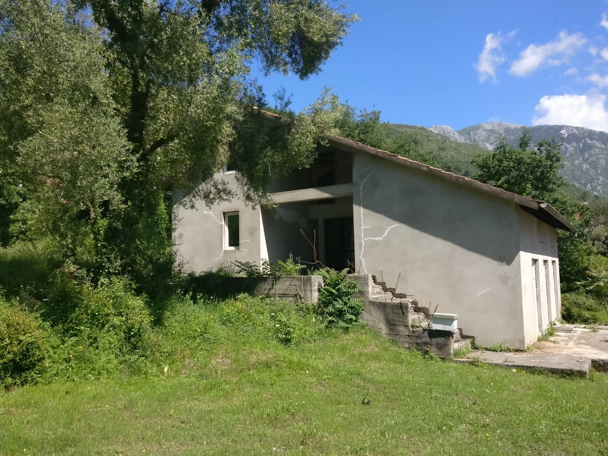 Two-story house for finishing in Kavac, Montenegro: concrete structure, tiled roof, and mountain view.