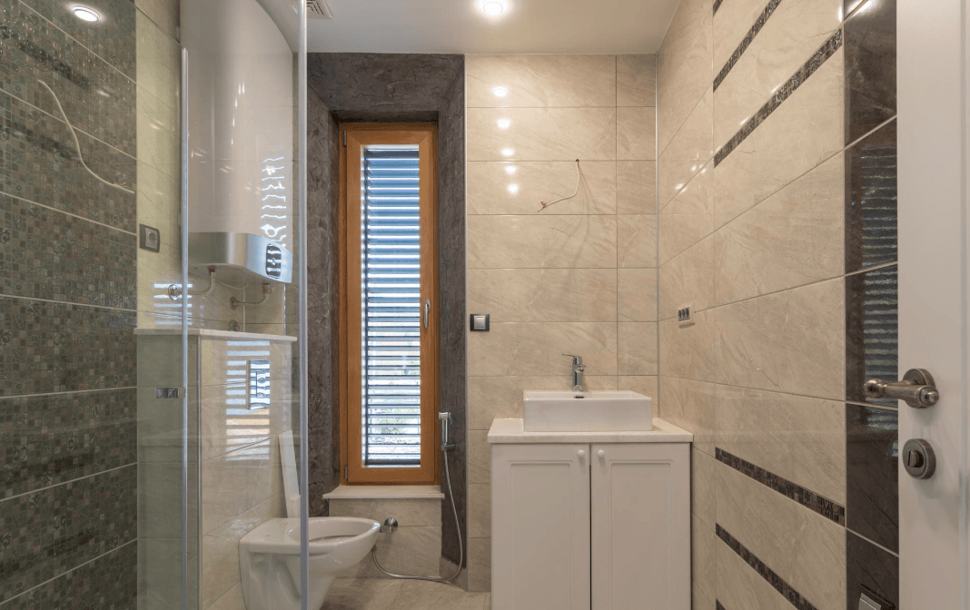 Modern bathroom with a shower cabin and a window in a villa in Bijela, Montenegro: stylish tile finish.
