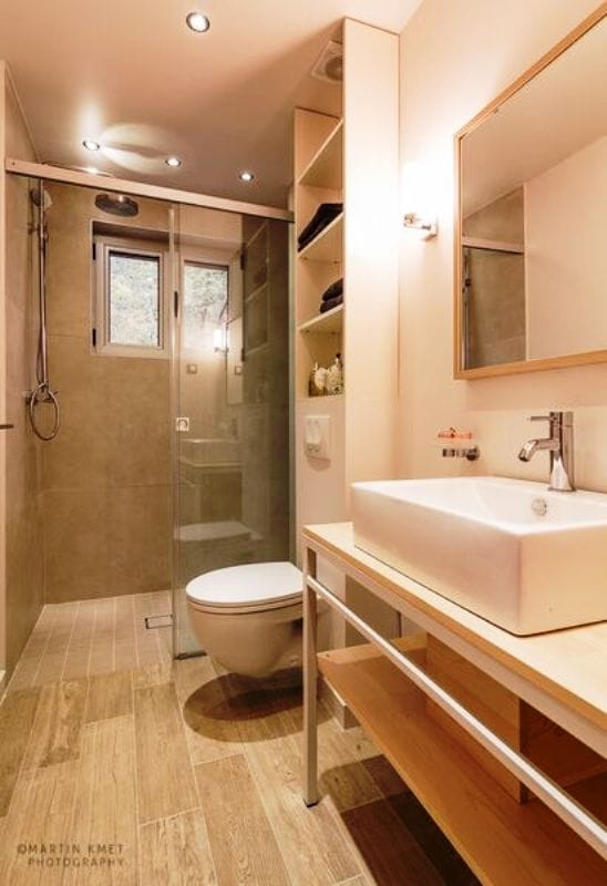Modern bathroom with a shower cabin in an apartment, Kavac, Montenegro: wood-look tiles, countertop sink.