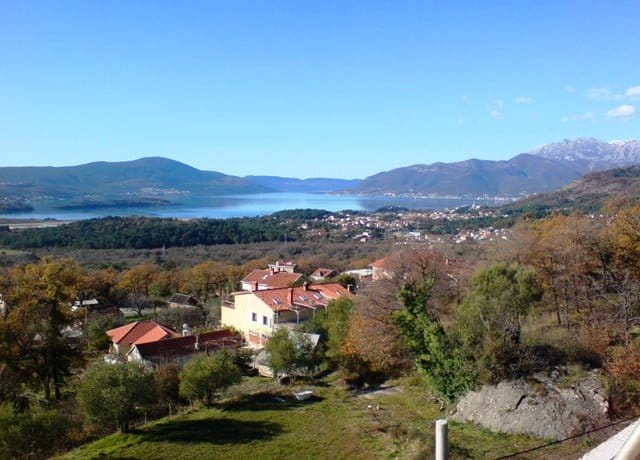 Panoramic view of Tivat Bay and the mountains from an apartment in Kavači, Montenegro: a private house and green landscape.
