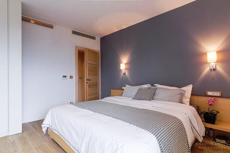 Modern bedroom with a double bed in an apartment, Kavač, Montenegro: stylish interior, gray wall and decor.