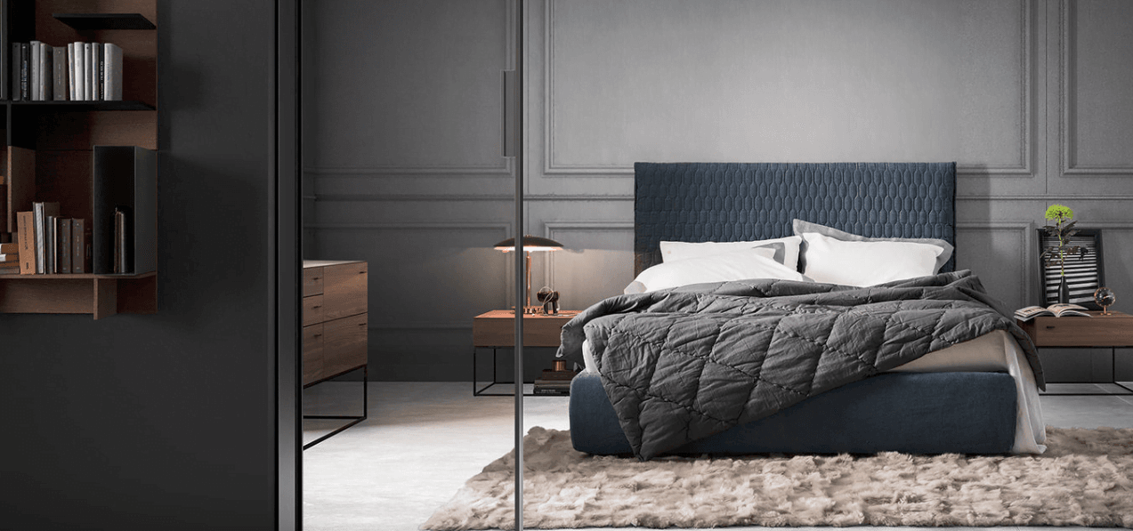 Modern bedroom in a residential complex in Rafailovići, Montenegro: blue bed, wooden furniture, and stylish decor.