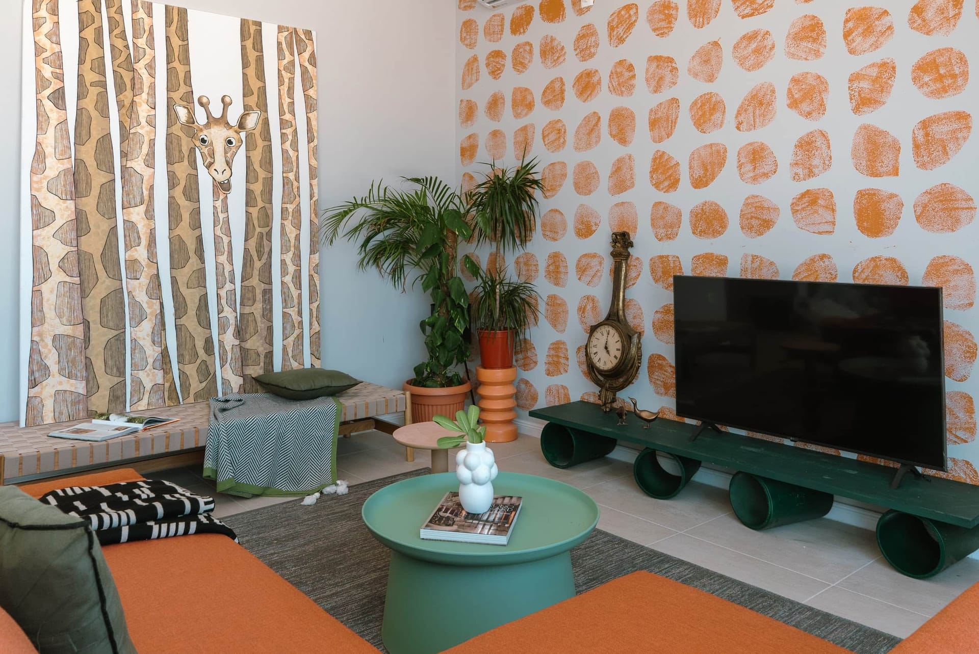 Designer living room in a villa in Krašići, Montenegro: bright decor, giraffe painting, TV area, and houseplants.