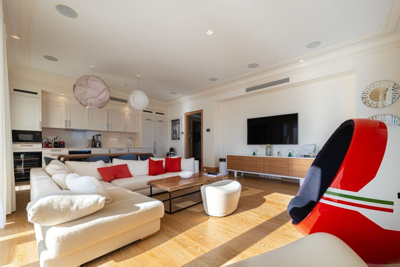 Modern living room with kitchen in an apartment in Porto Montenegro, Tivat, Montenegro: bright interior, designer armchair.