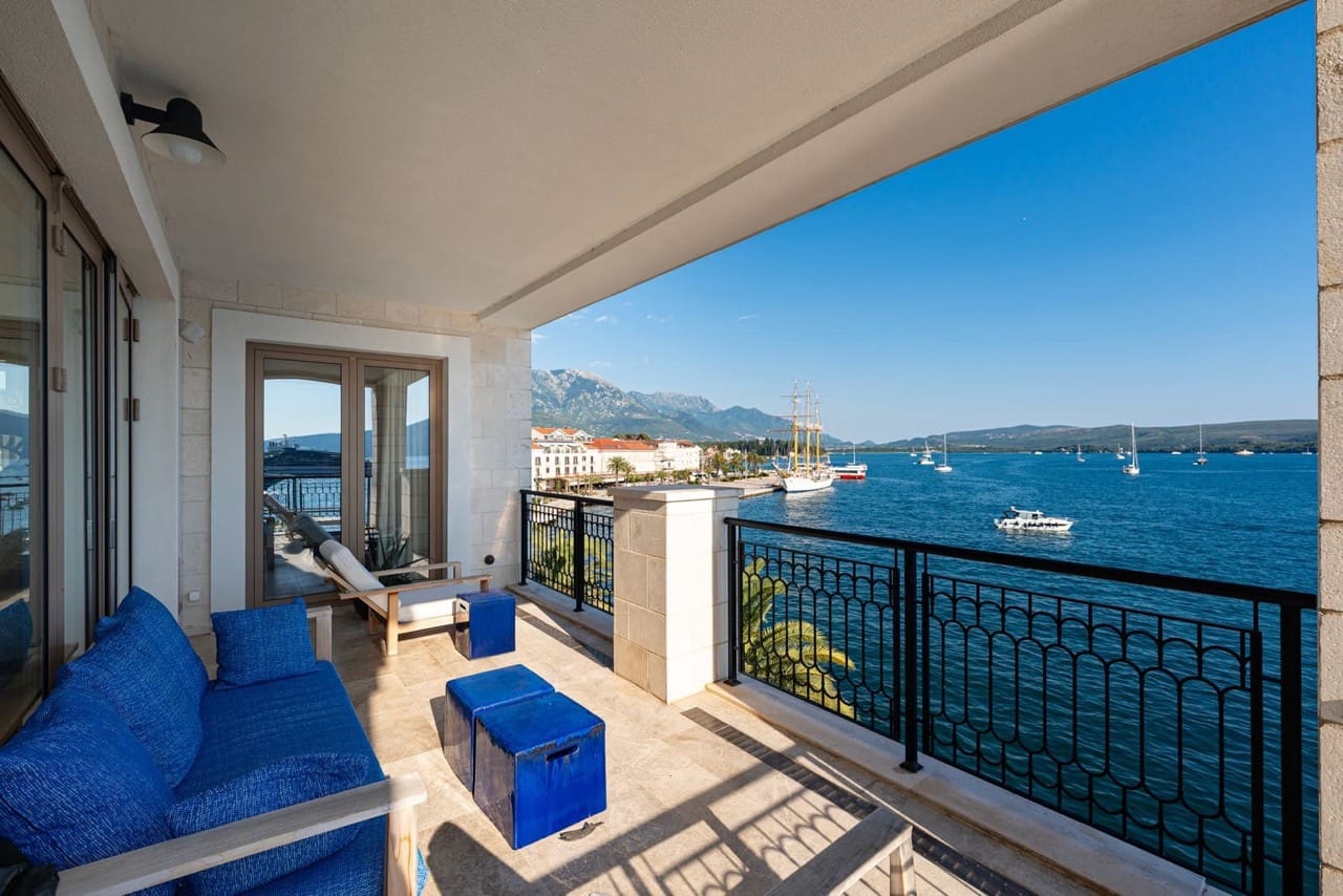 Terrace with a view of the sea and yachts in Porto Montenegro, Tivat, Montenegro: blue furniture, stone finishes, and a panoramic view.