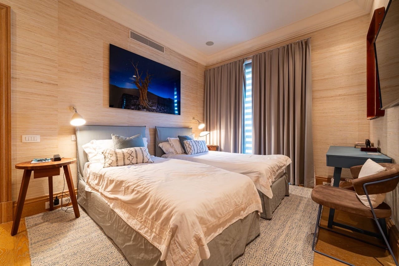 Bedroom in an apartment in Porto Montenegro, Tivat, Montenegro: two beds, designer furniture, and wallpaper wall finish.