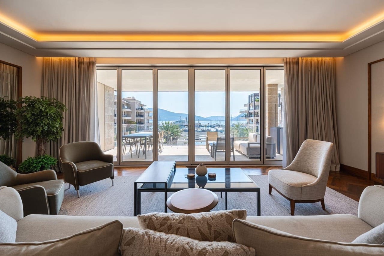 Living room in an apartment in Porto Montenegro, Tivat, Montenegro: panoramic windows with marina views and modern furniture.