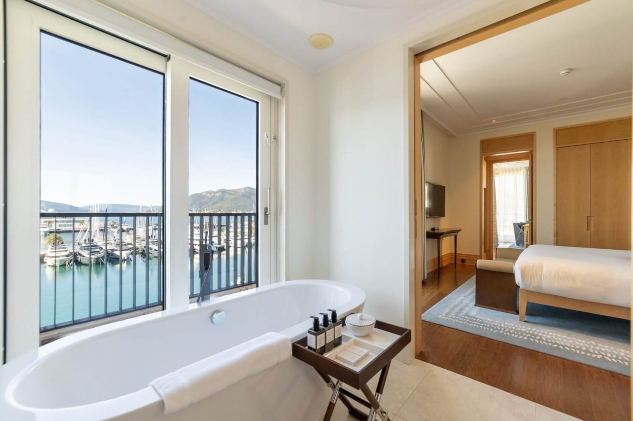 Bathroom with a view of the marina in Porto Montenegro apartments, Tivat, Montenegro: bathtub and bedroom interior.
