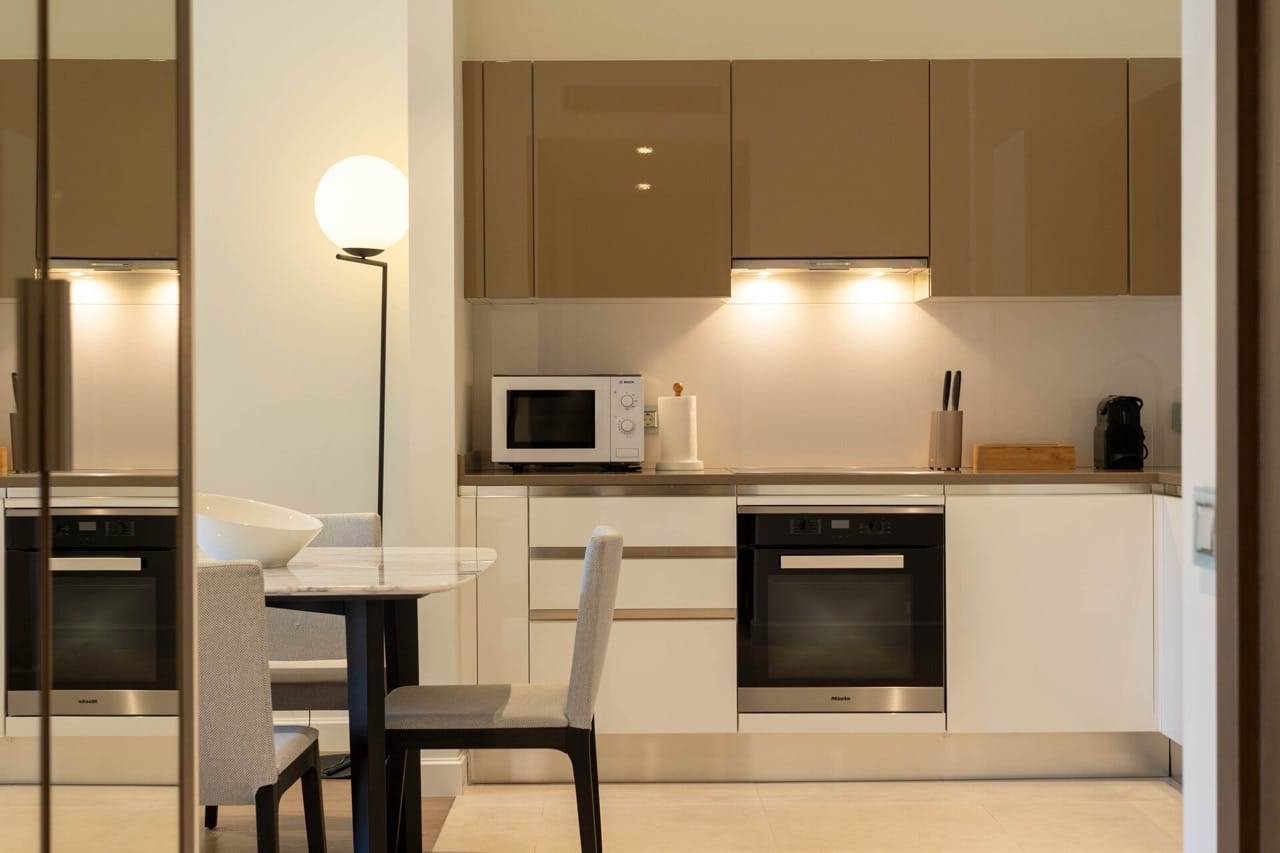 Modern kitchen in an apartment in Portonovi, Kumbor, Montenegro: glossy fronts, Miele appliances, and a dining area.