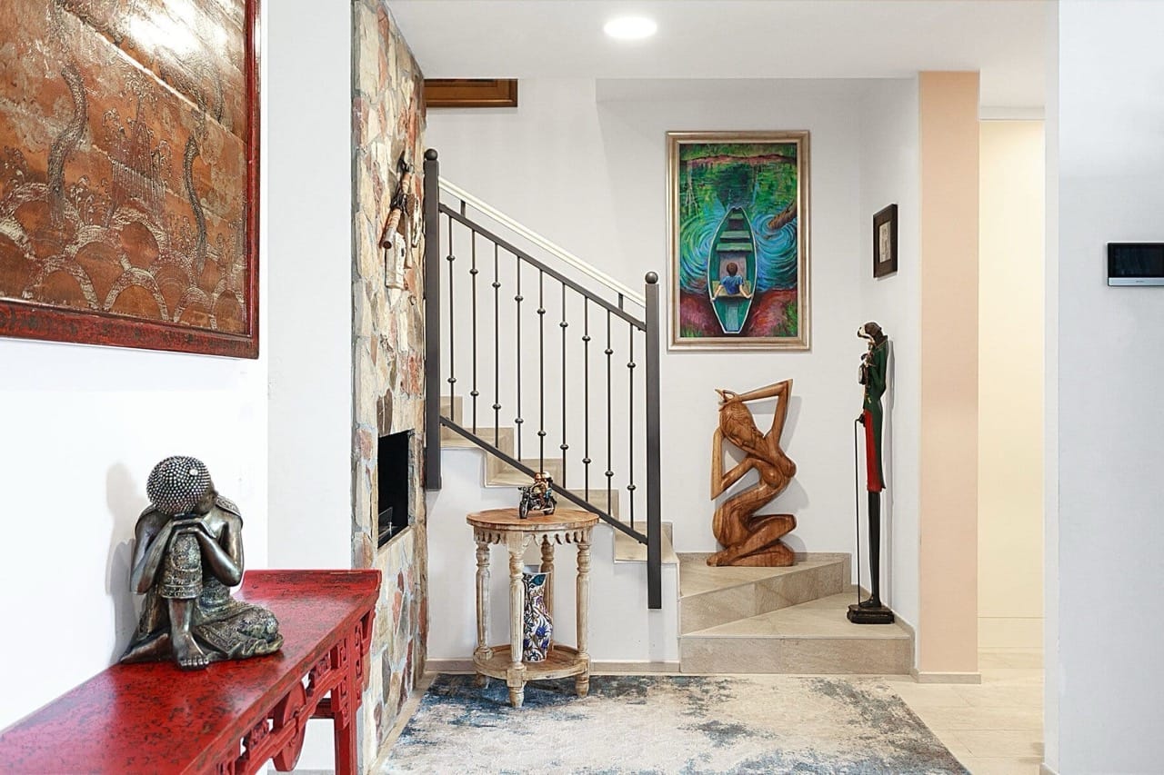 Living room interior in a villa in Luštica Bay, Radovići, Montenegro: staircase with wrought-iron railings and ethnic-style decor.