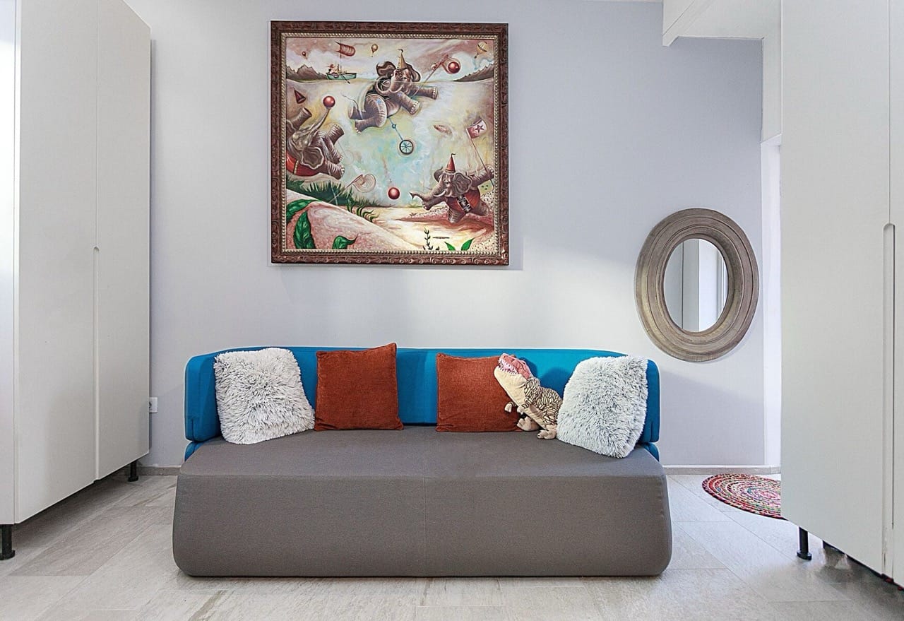 Modern living room with a blue sofa and a painting in a villa in Luštica Bay, Radovići, Montenegro.