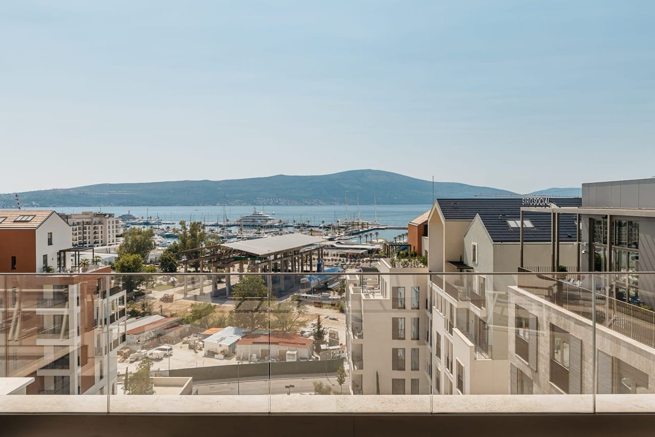 View from the apartment balcony in Porto Montenegro, Tivat, Montenegro: a panorama of the marina, yachts, and mountain scenery.