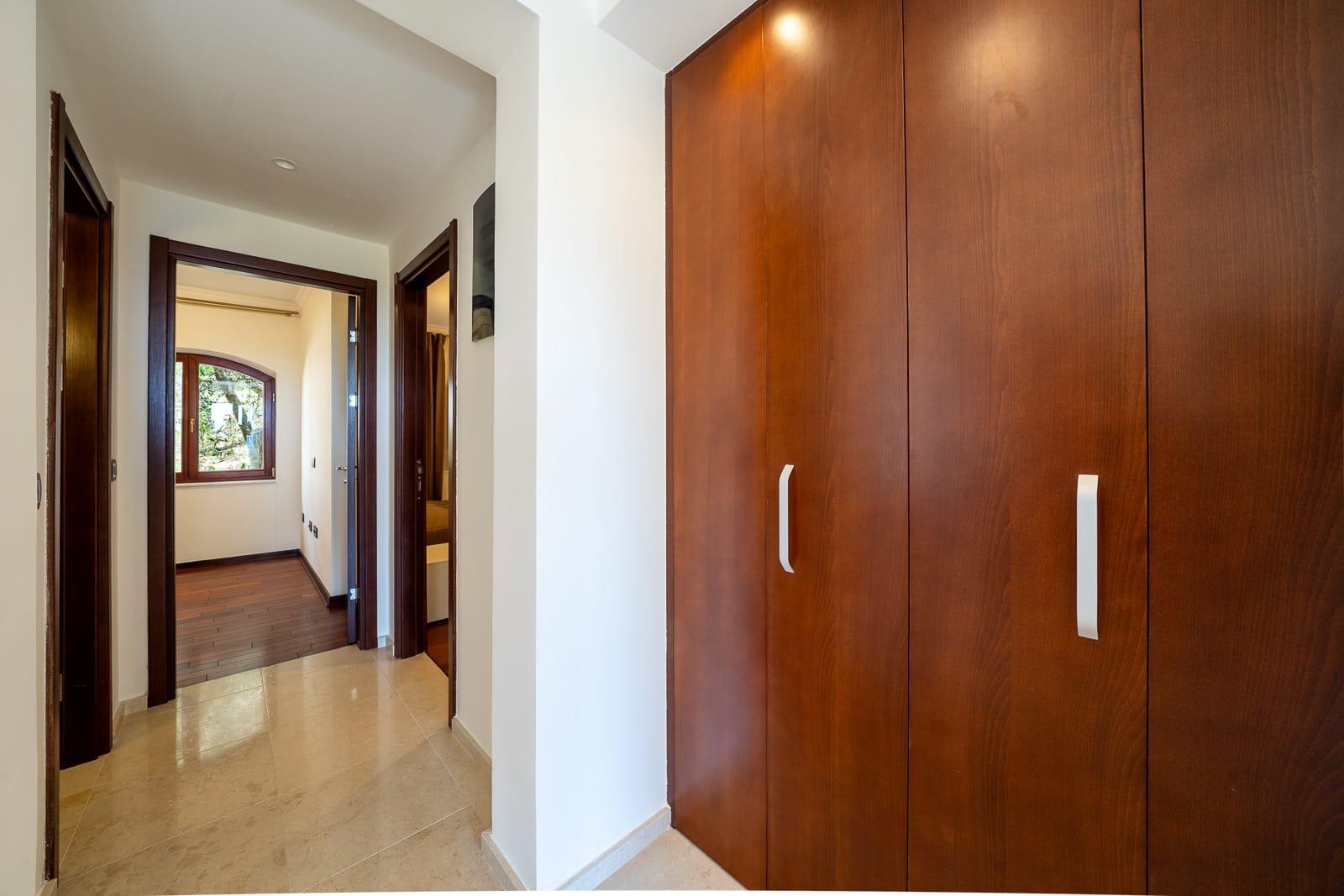 Hallway with a large built-in wardrobe and light flooring in an apartment in Petrovac, Montenegro. View of adjoining rooms.