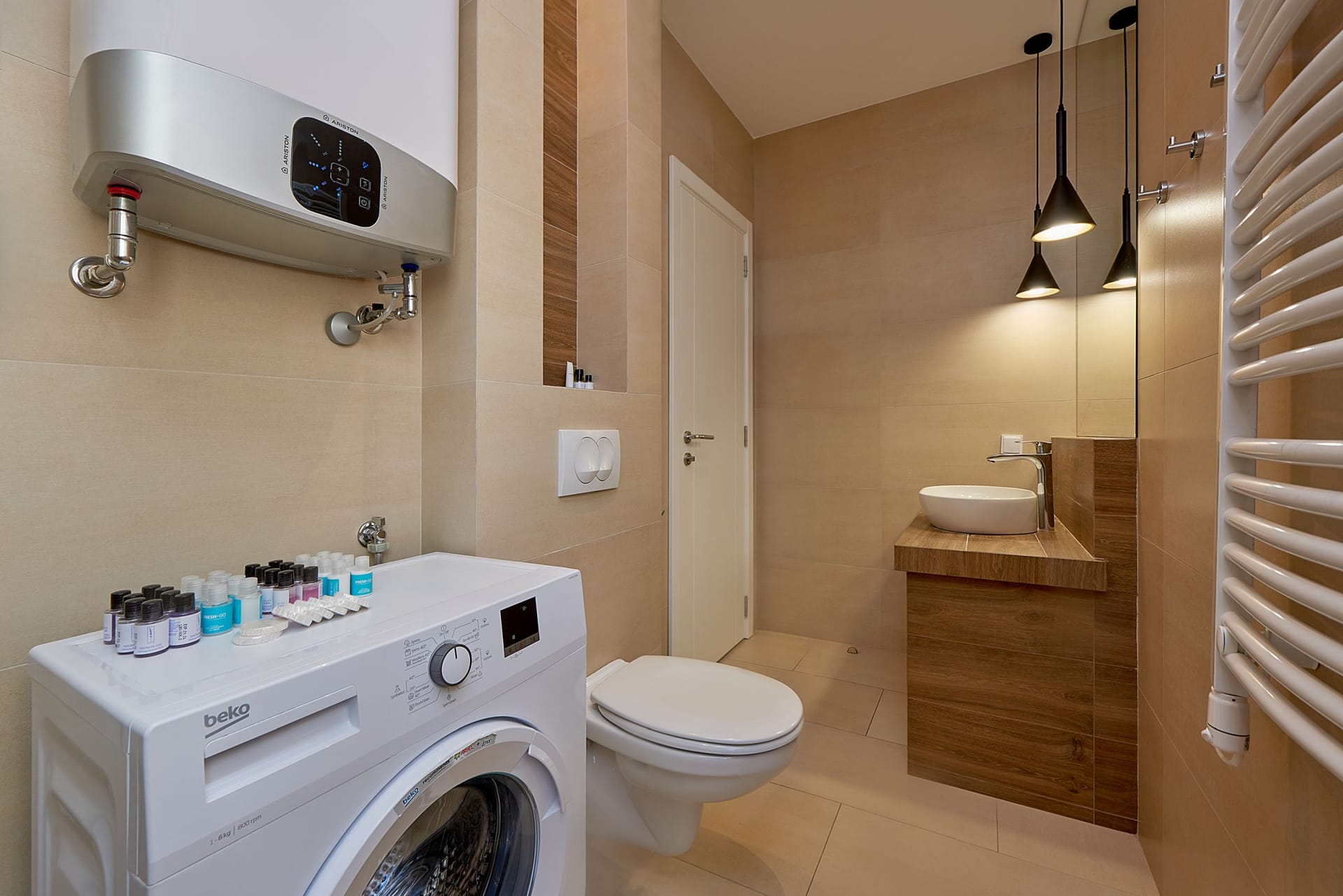 Modern bathroom with a shower and washing machine in an apartment in Bečići, Montenegro.