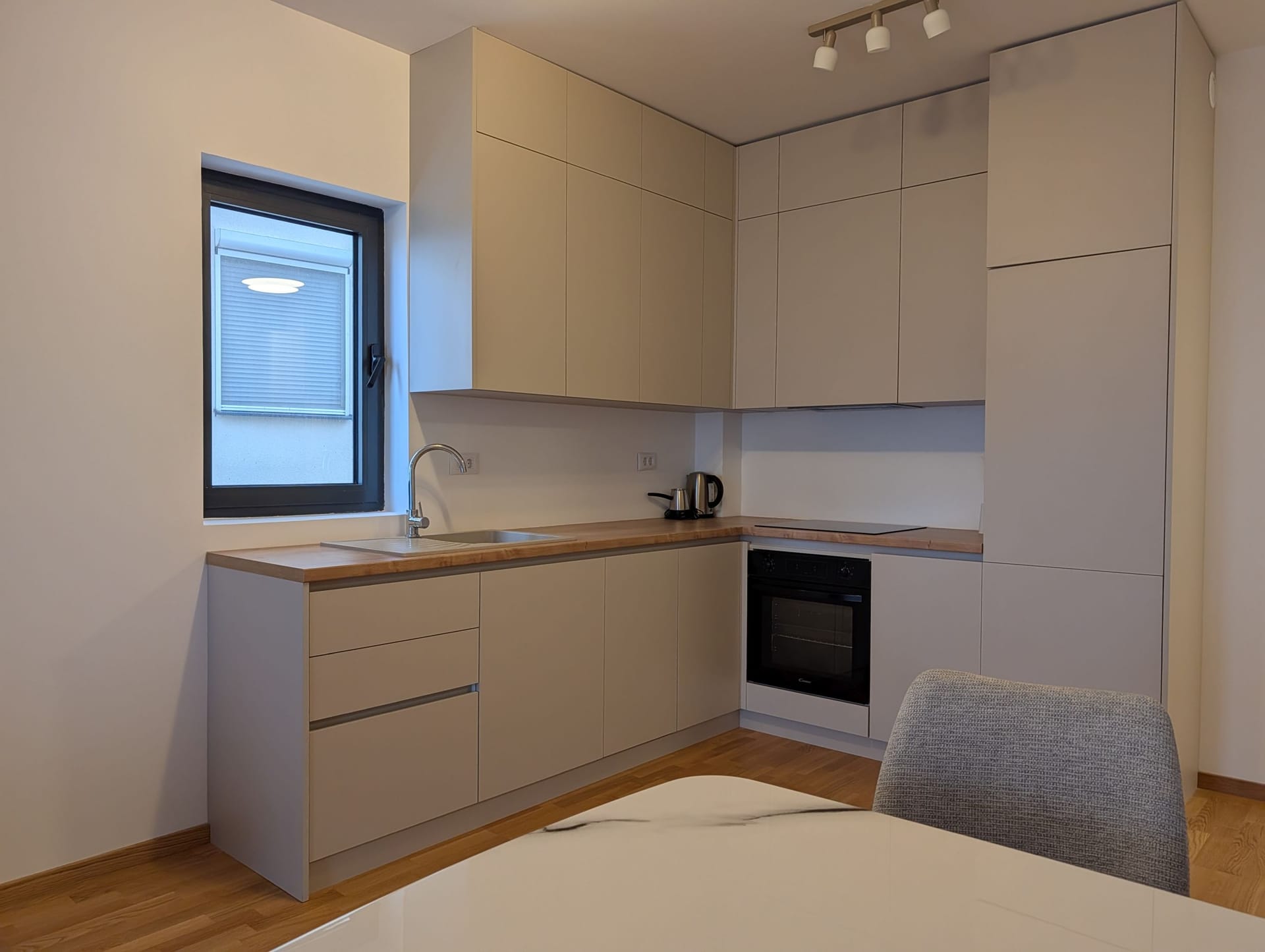 Modern kitchen in light tones with a wooden countertop in an apartment, Bečići, Montenegro.