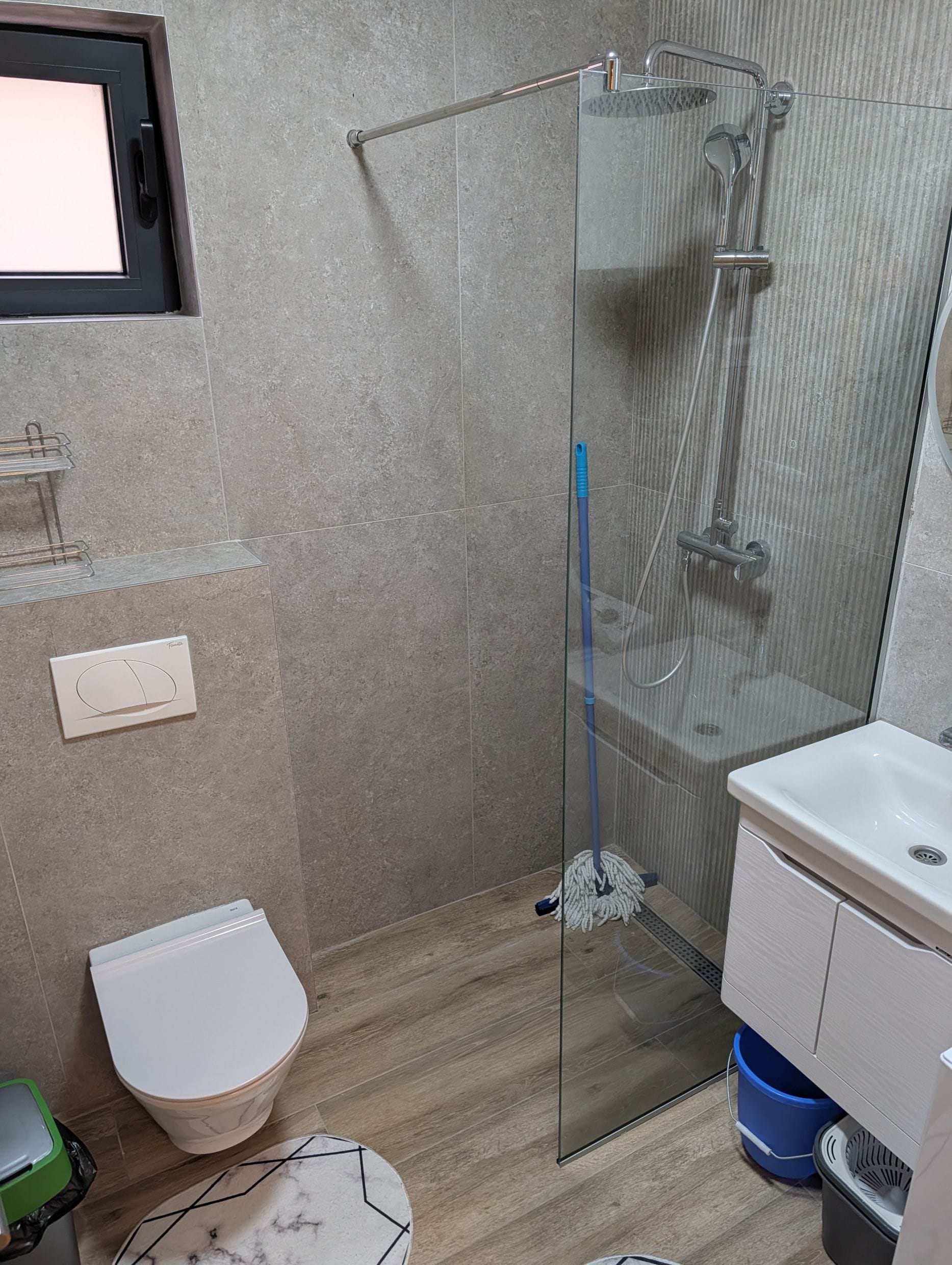 Modern bathroom with a shower cabin and gray tiles in an apartment in Bečići, Montenegro.