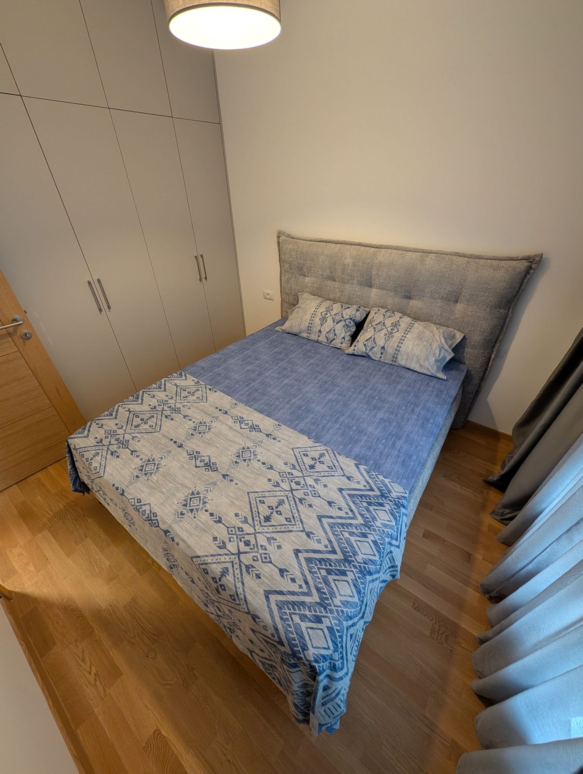 Cozy bedroom with a double bed and built-in wardrobe in an apartment in Bečići, Montenegro. Modern interior.