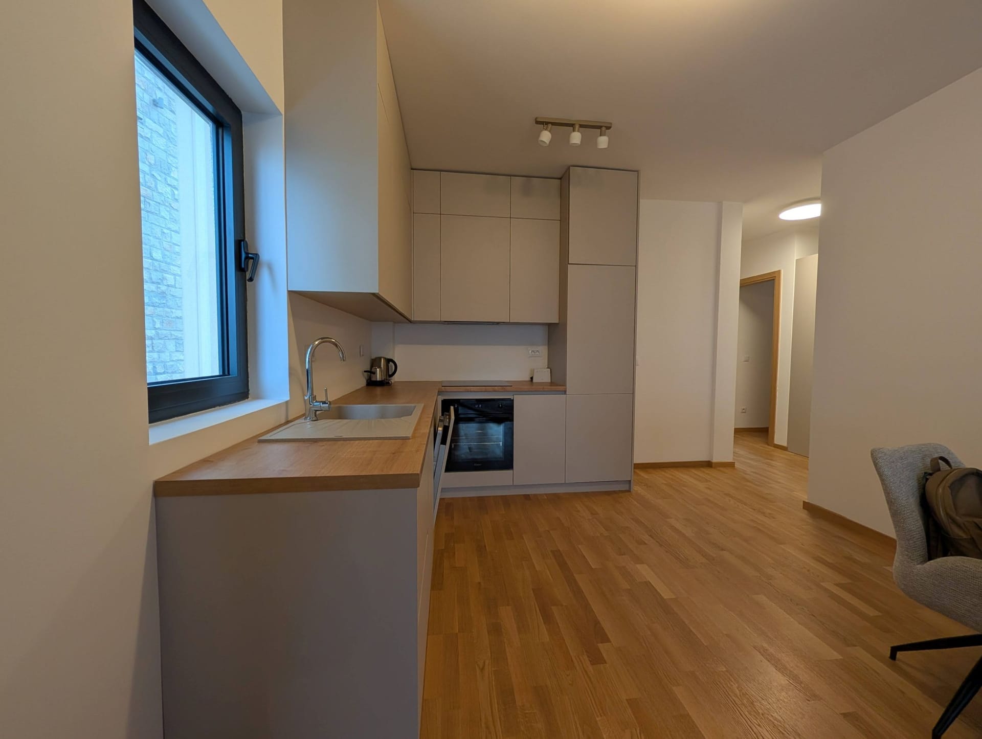 Modern kitchen with light-colored fronts and a wooden countertop in an apartment in Bečići, Montenegro.