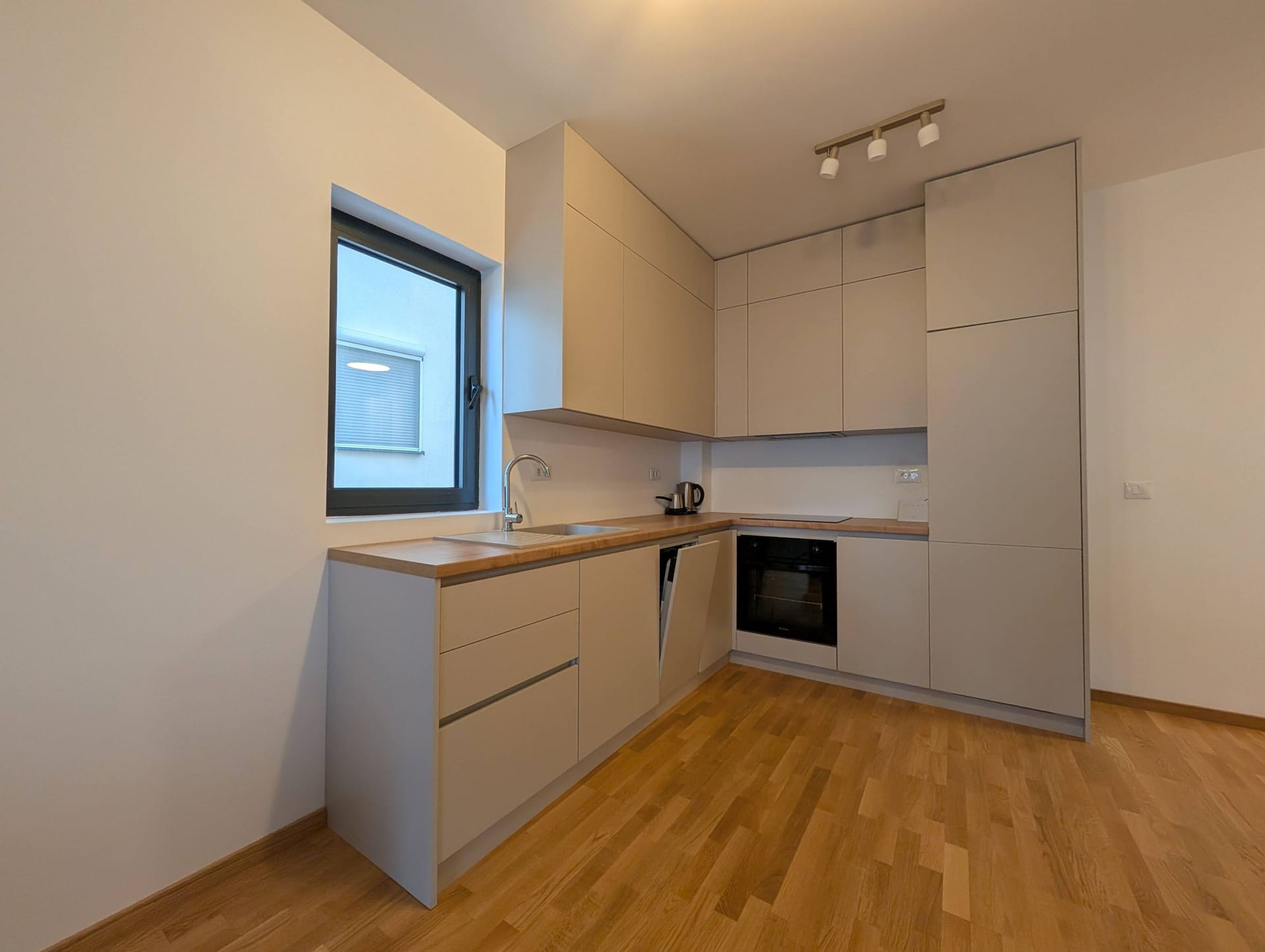 Modern kitchen in light tones with a wooden countertop in an apartment, Bečići, Montenegro.
