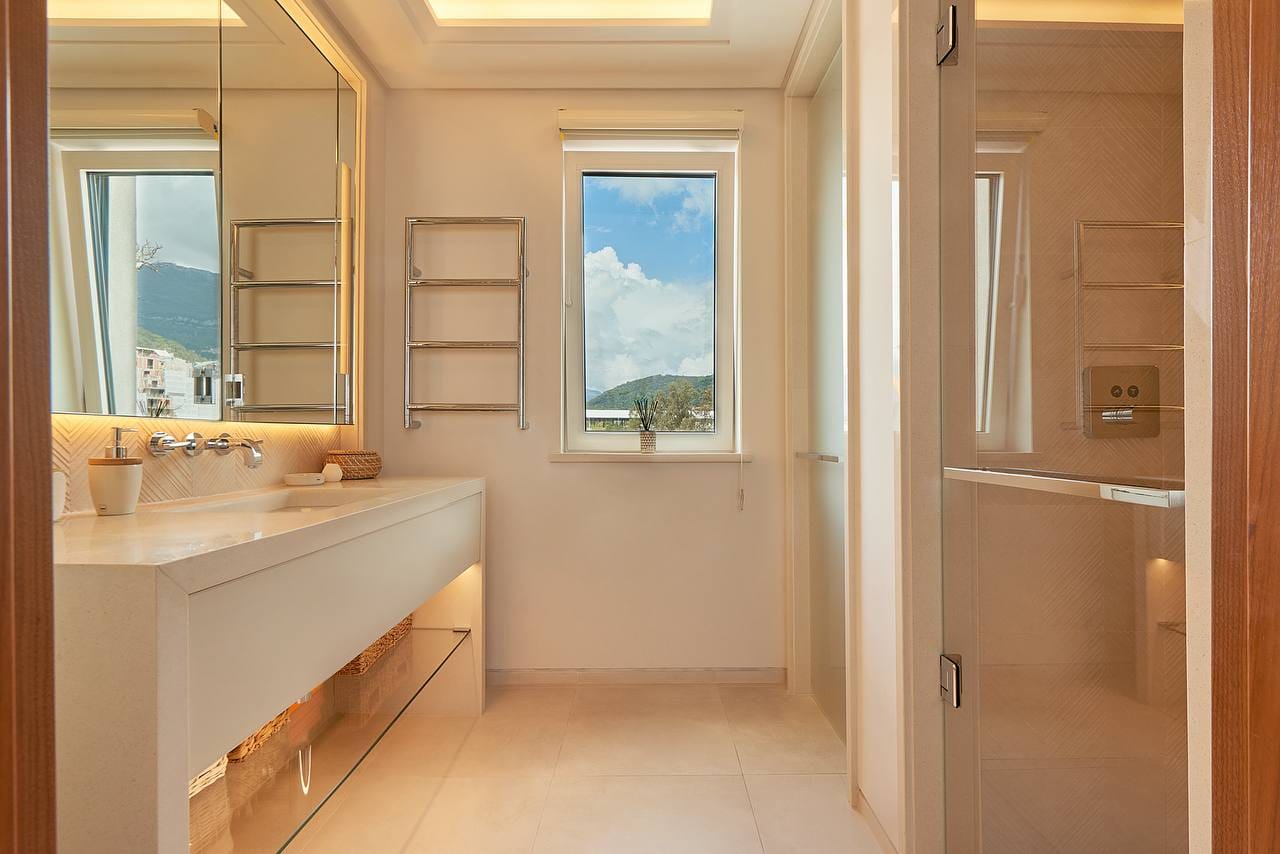 Modern bathroom in an apartment in Porto Montenegro, Tivat, Montenegro: light finishes, shower, and mountain view.