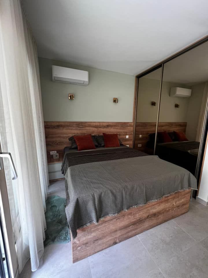 Bedroom in a studio in Kotor, Montenegro: double bed, mirrored wardrobe, and air conditioning in a modern interior.