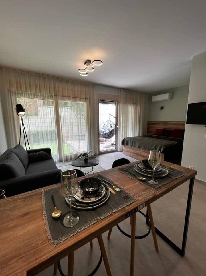 Modern studio in Kotor, Montenegro: living room with dining area, double bed, and access to the terrace.