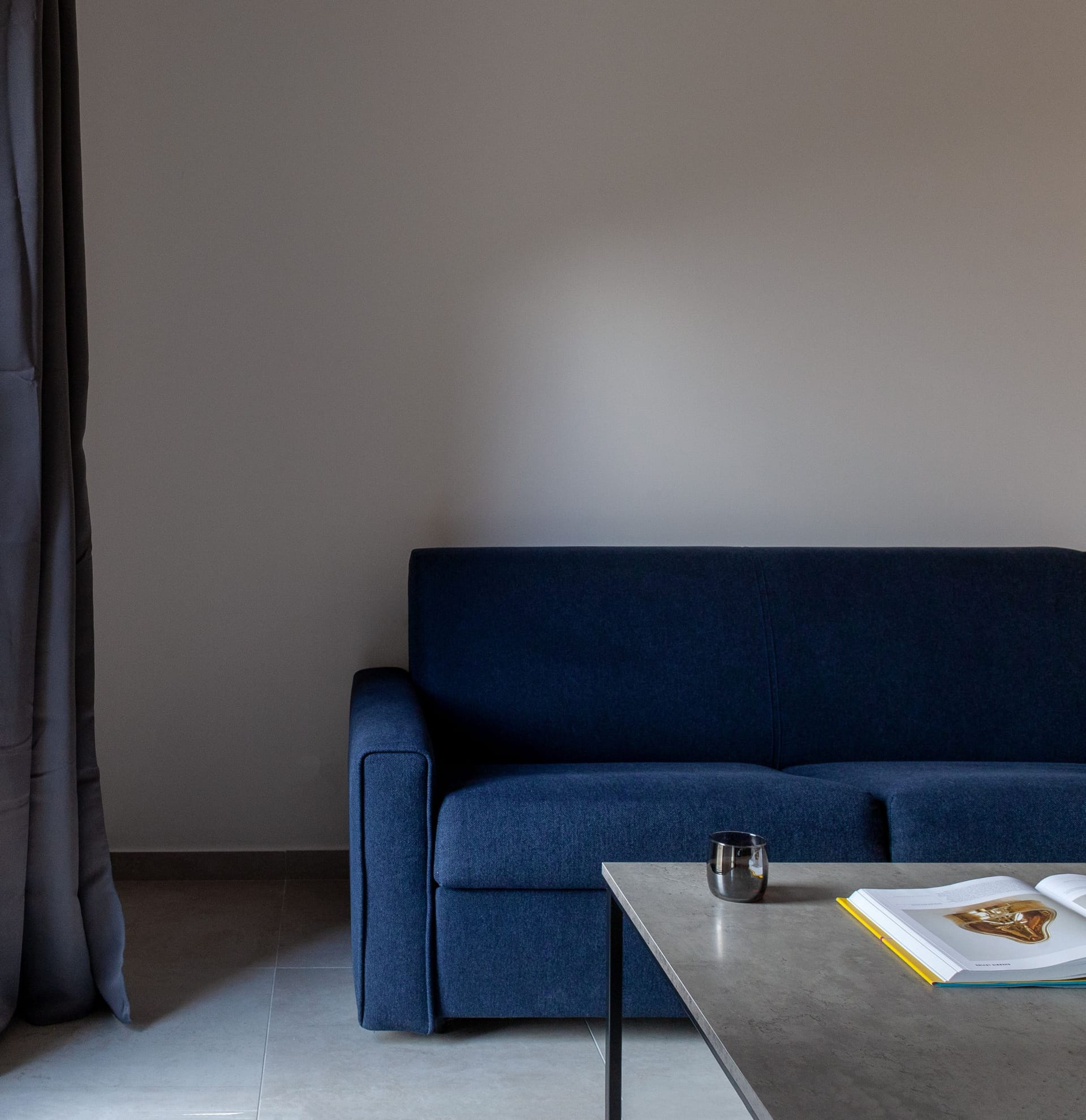 Modern living room with a blue sofa and coffee table in an apartment in Kotor, Montenegro.