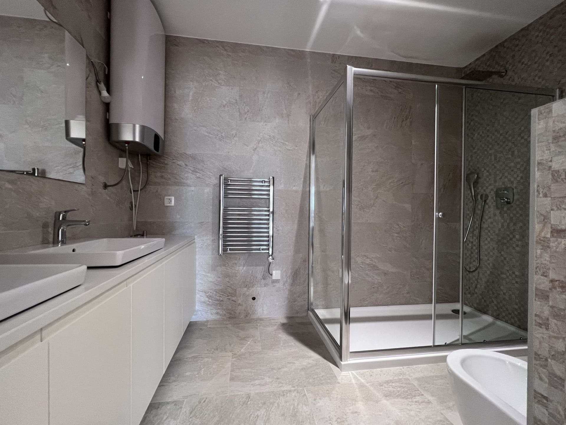 Modern bathroom with a shower cabin and light finishes in an apartment, Kotor, Montenegro.