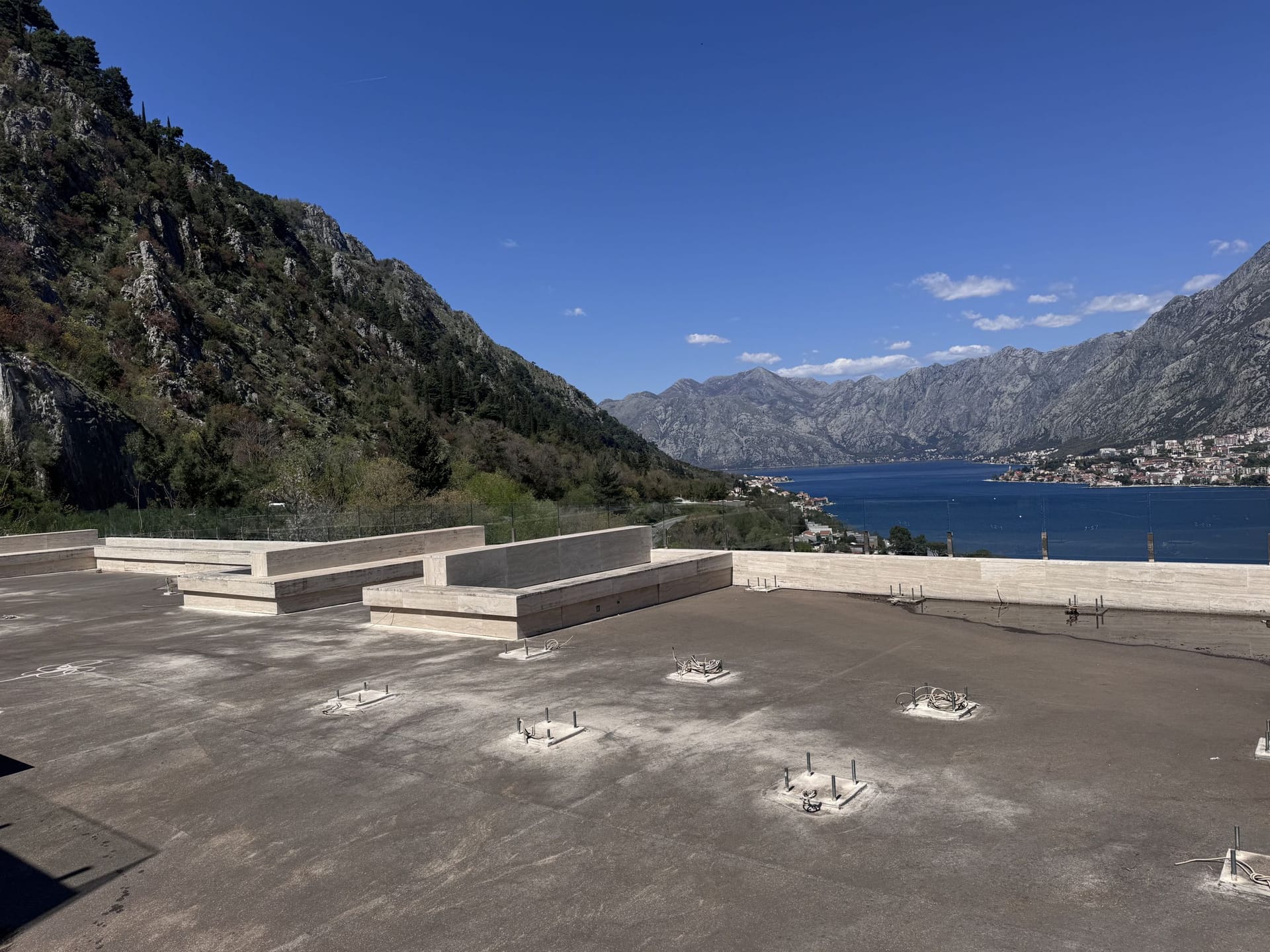 Open terrace with stone benches and panoramic views of Kotor Bay and the mountains, Montenegro.