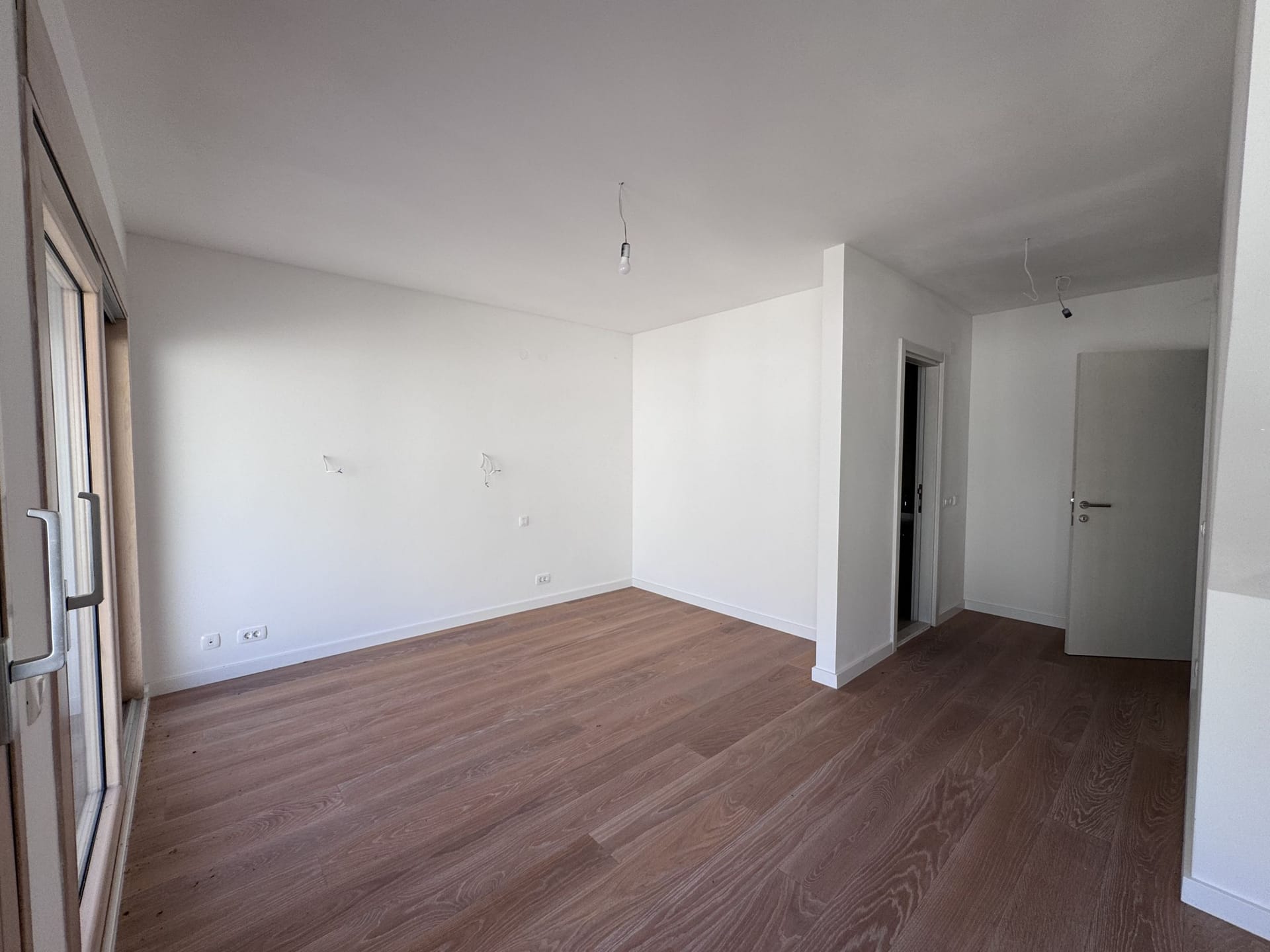 Bright living room with parquet flooring and white walls in a new apartment, Kotor, Montenegro.