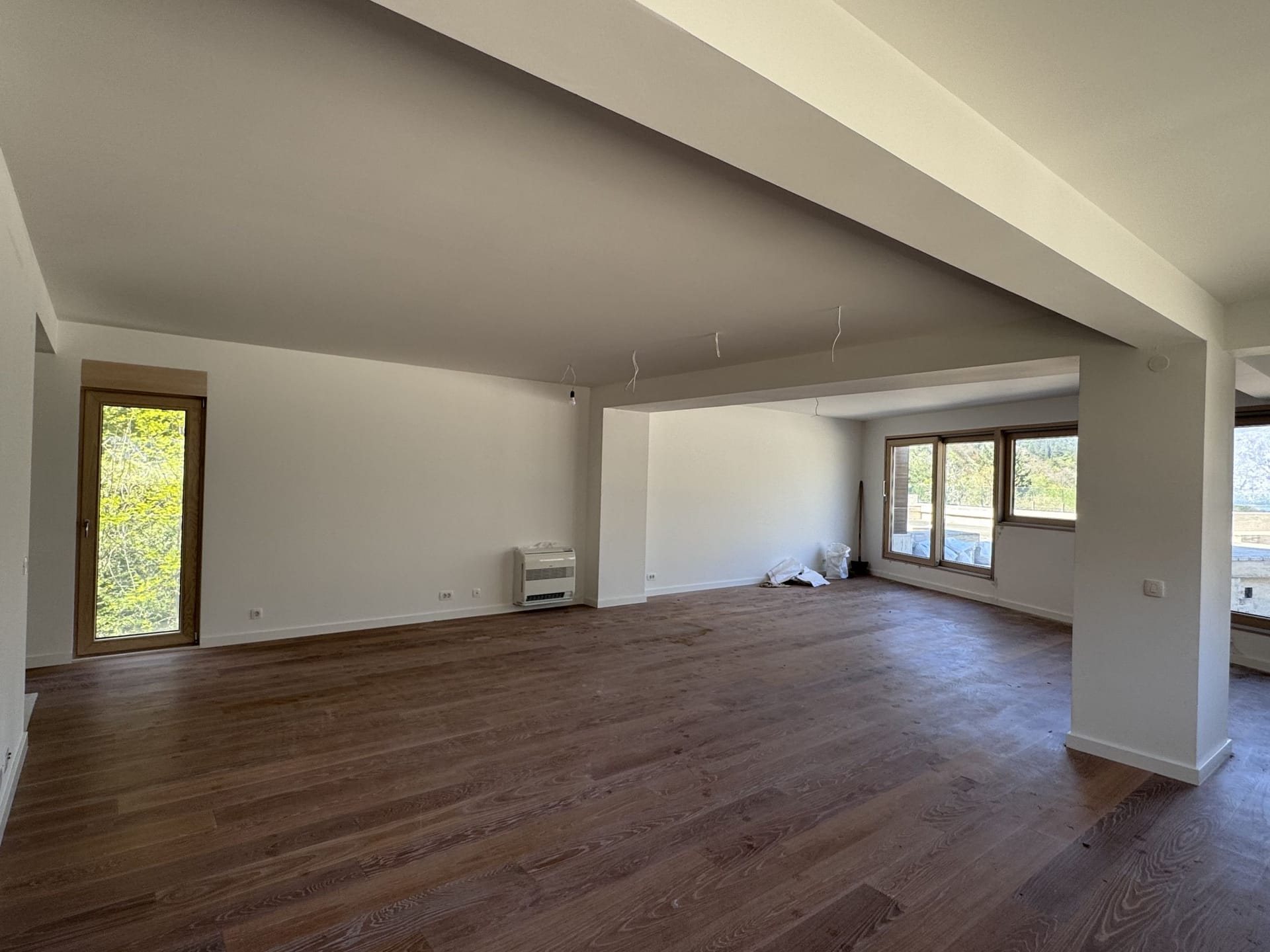Spacious living room with wooden floors and panoramic windows in a new apartment, Kotor, Montenegro.