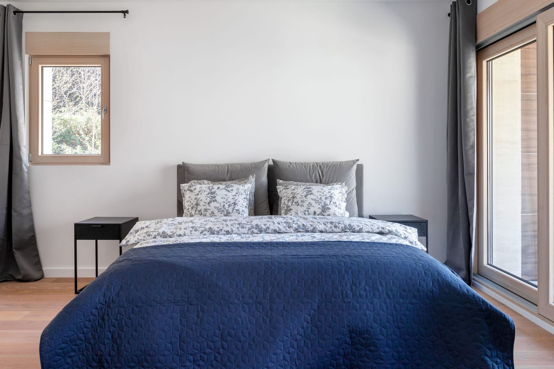 Modern bedroom with a double bed in an apartment in Kotor, Montenegro: panoramic windows and a bright interior.