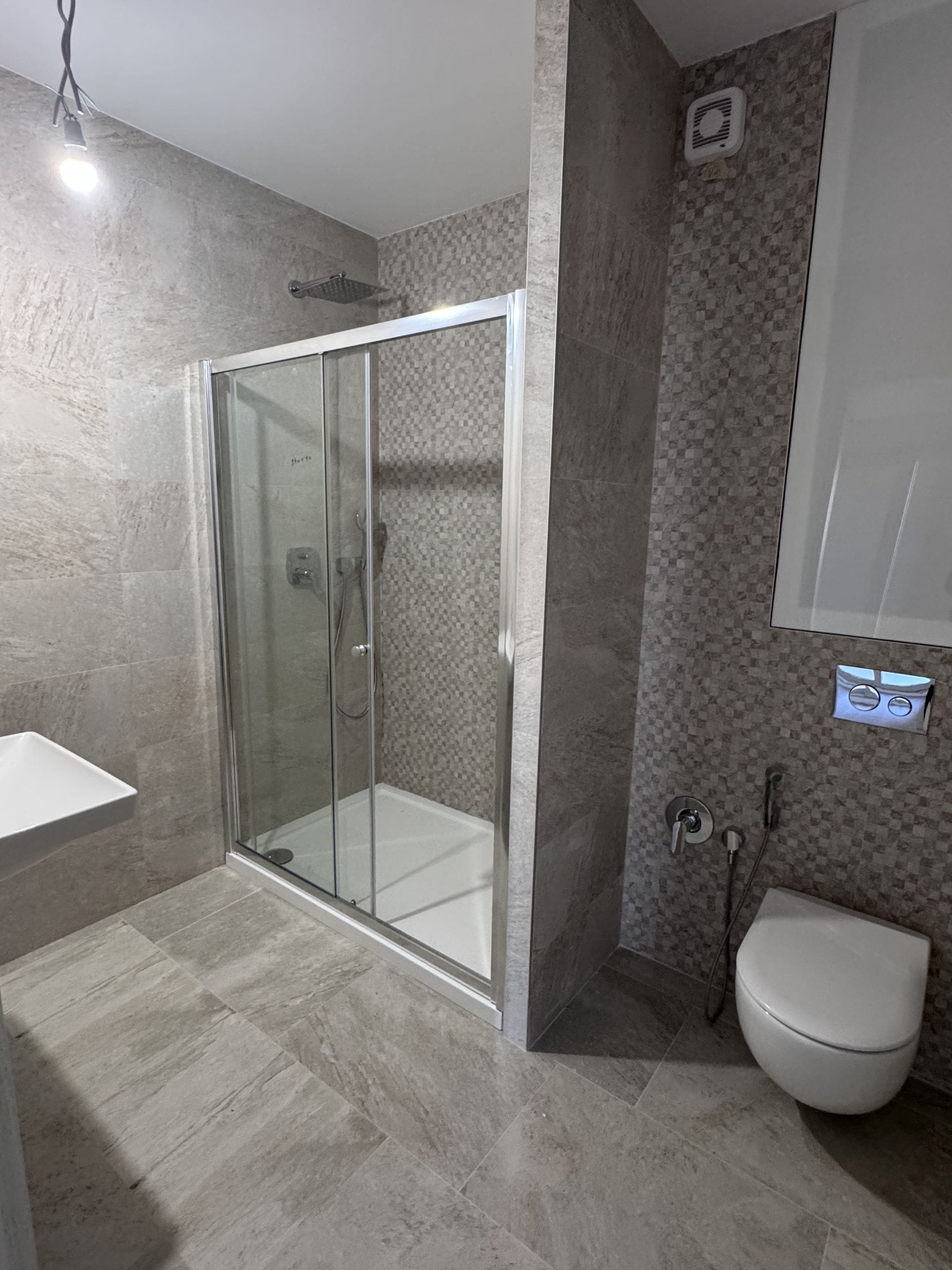 Modern bathroom with a shower cabin and tiled finishes in an apartment in Kotor, Montenegro.