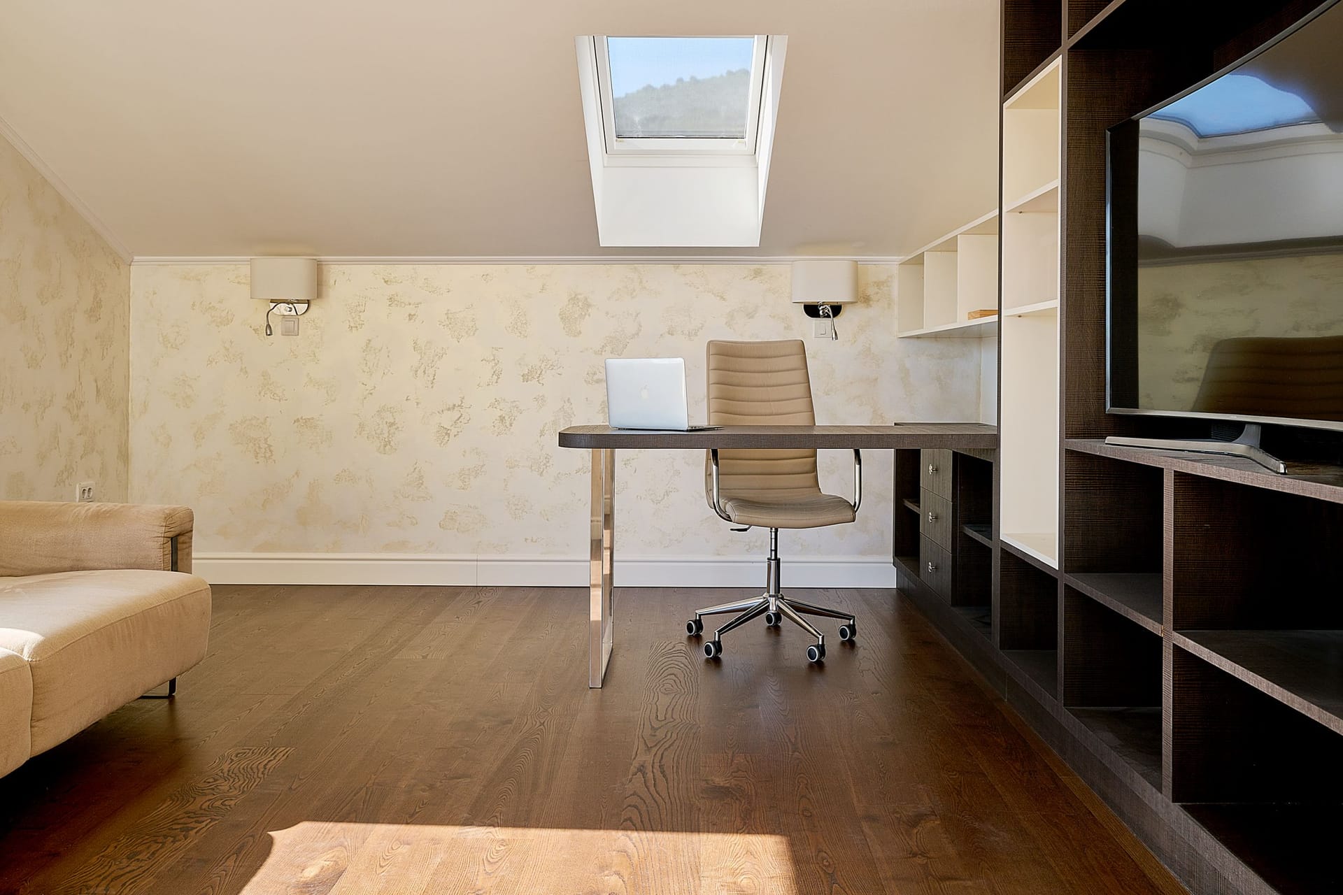 Home office in a loft apartment in Budva, Montenegro: desk, armchair, and shelving unit in a modern interior.