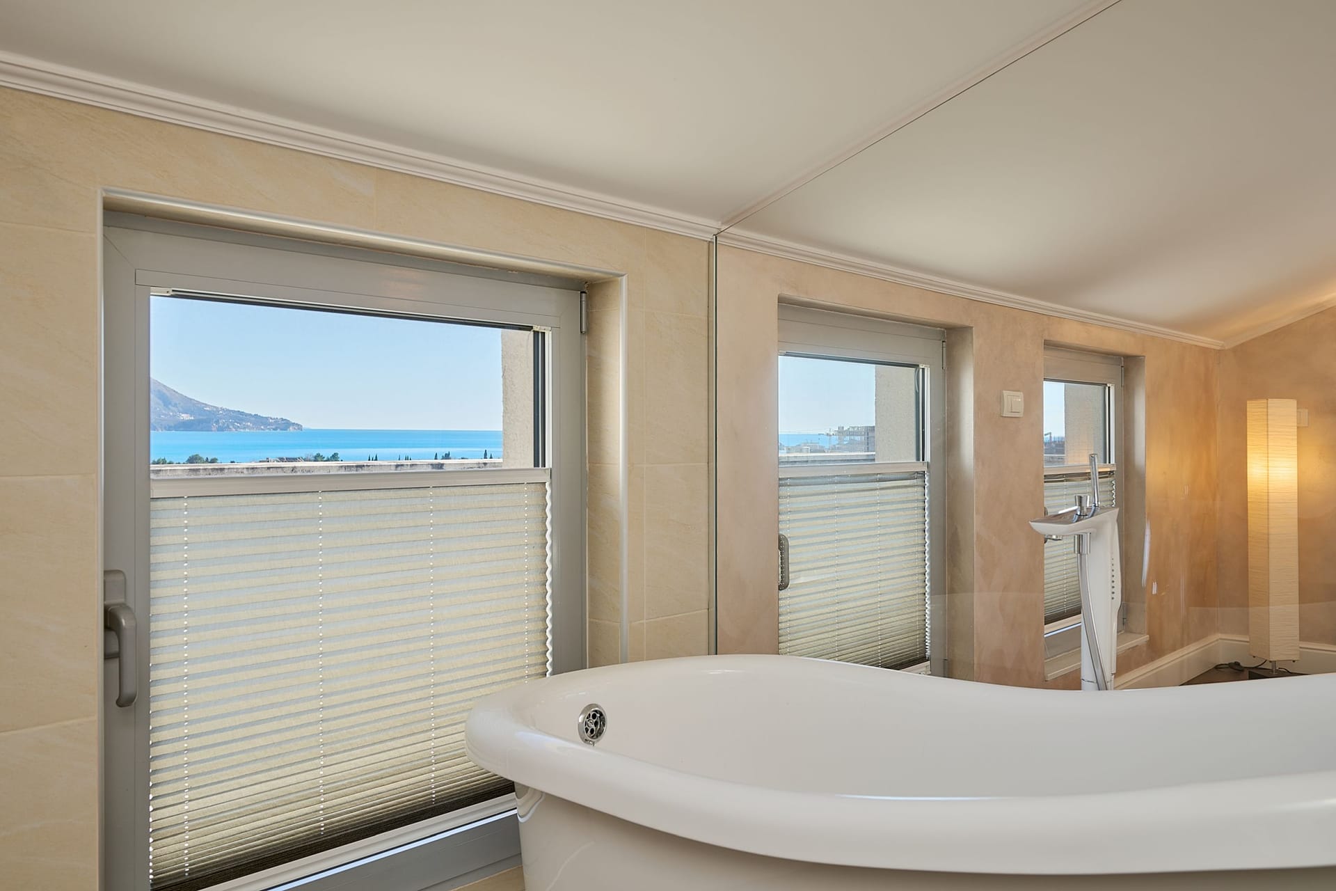 Bathroom with a freestanding bathtub and panoramic sea view in an apartment in Budva, Montenegro.