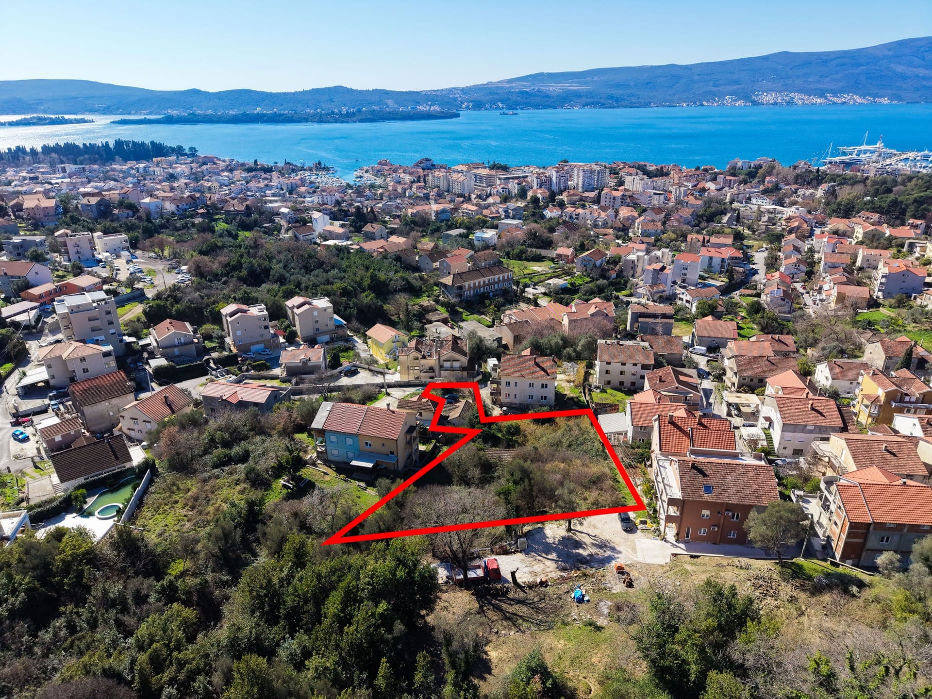 Building plot in Tivat, Montenegro, with panoramic sea and city views from a bird’s-eye perspective.